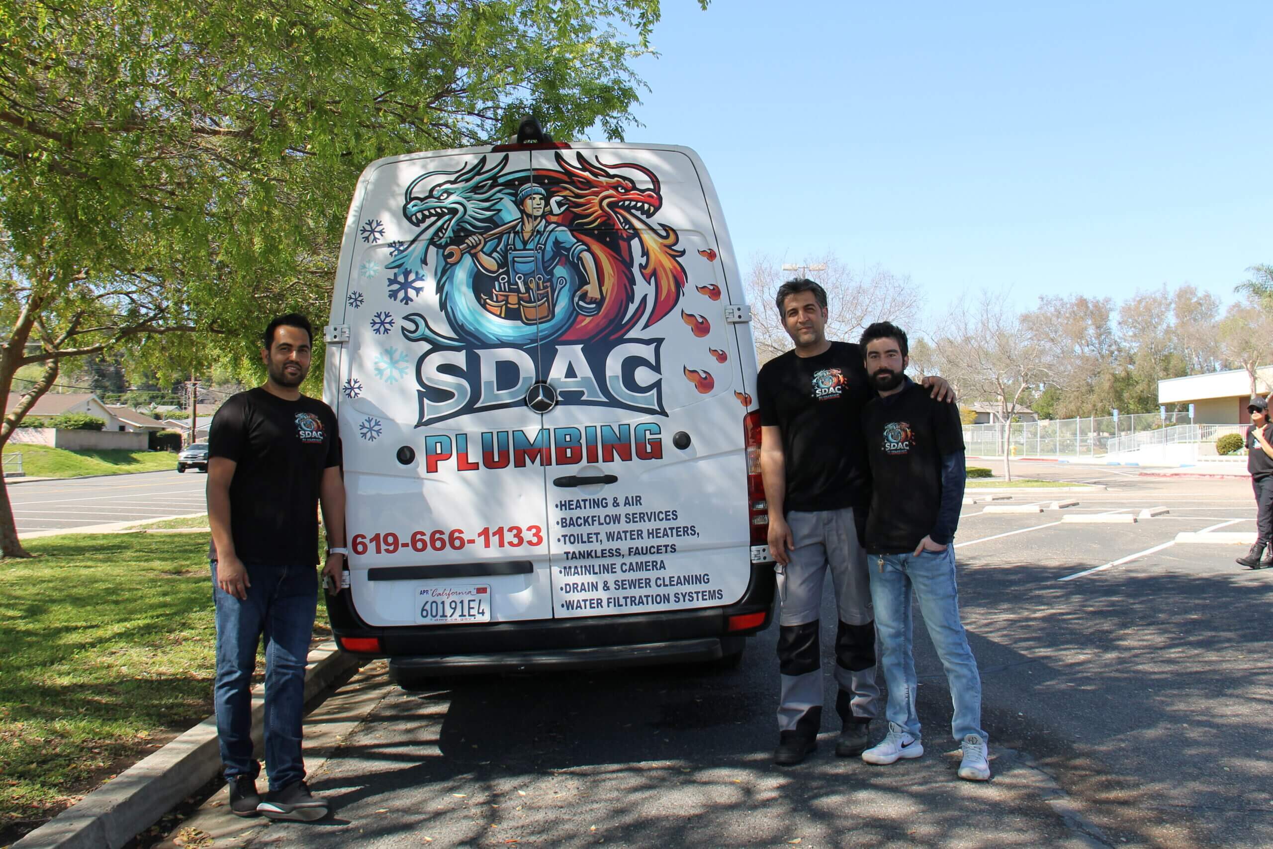 SDAC Plumbing technicians and staff standing together with branded corporate vans, ready to deploy for residential plumbing and HVAC services.